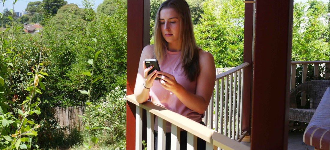 girl on her phone on a balcony 1